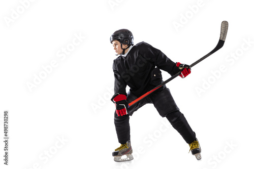 Winning game. Portrait of concentrated boy, child, hockey player in motion, training isolated over white background.