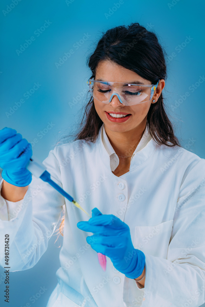Student in White Coat, Working in Research Laboratory Using Micro Pipette and Test Tube Student in White Coat, Working in Research Laboratory Using Micro Pipette and Test Tube