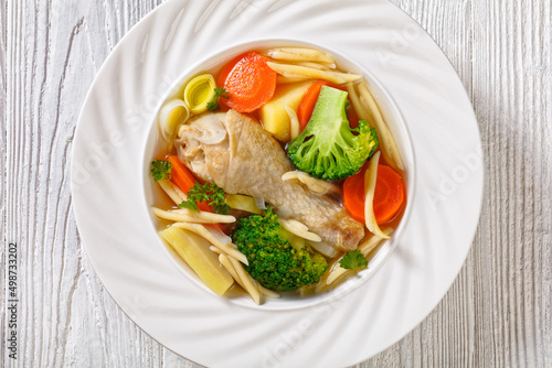chicken vegetable soup with pasta in white bowl