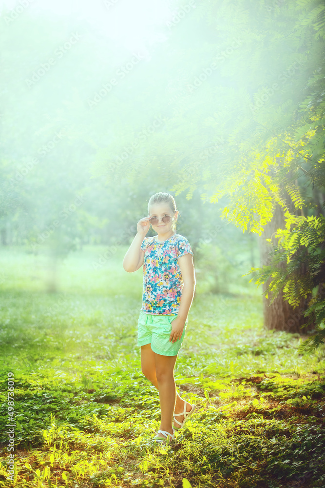 A school-age girl walks in the park. A school-age girl walks in the park.