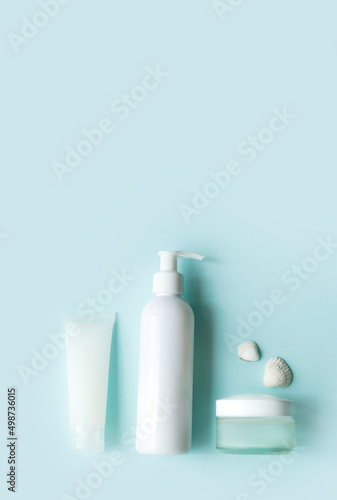 Eco-friendly cosmetics for face and body skin care. White tube, bottle and jar of cream on a blue background. Hard Shadows.