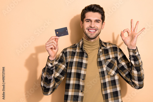 Photo of positive banker demonstrate debit card make okay sign advise savings offer isolated pastel color background © deagreez