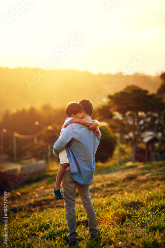 Dads warm hugs are the best. Shot of a father and his little son bonding together outdoors.