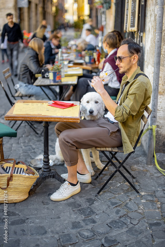 Canvas Print Man sitting with a dog at restaurant on the street in Rome