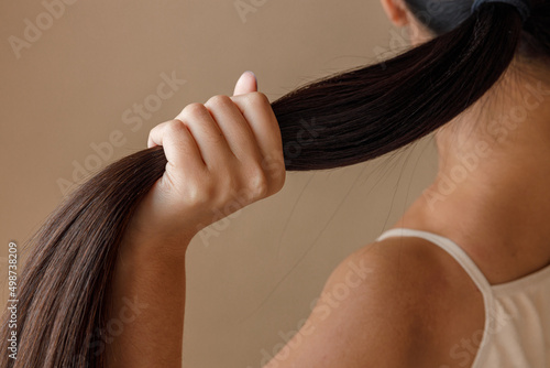 Young woman hand holding ponytail in studio photo