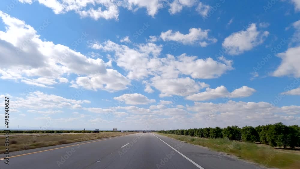 Driving along a country road by an orchard on a picturesque day towards and endless horizon - slow motion Driving along a country road by an orchard on a picturesque day towards and endless horizon - slow motion