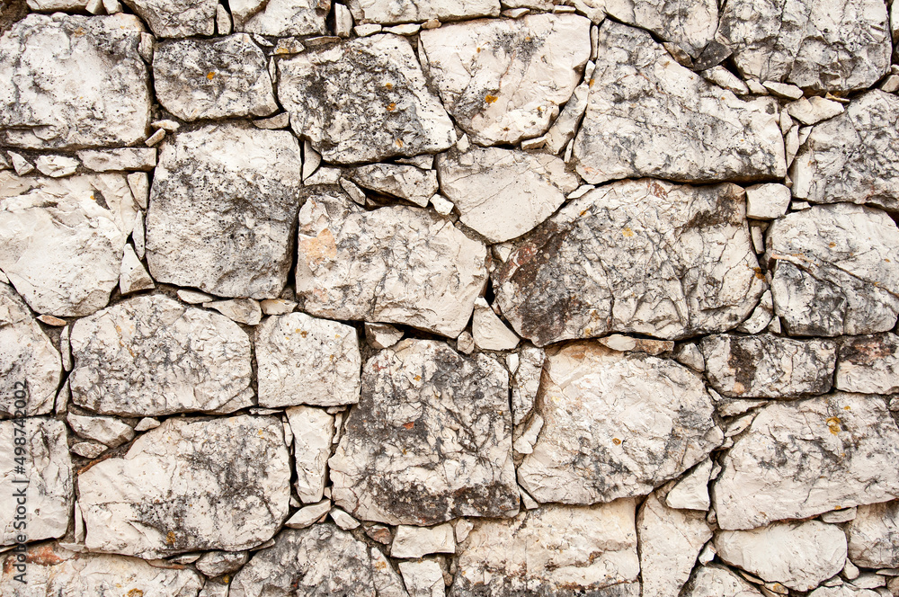 Rugged, white stone wall background texture.