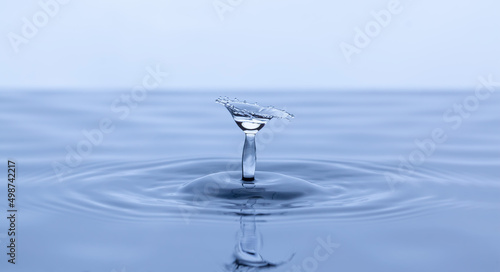 Splash and umbrella on white background. Reflection on the surface of the water.