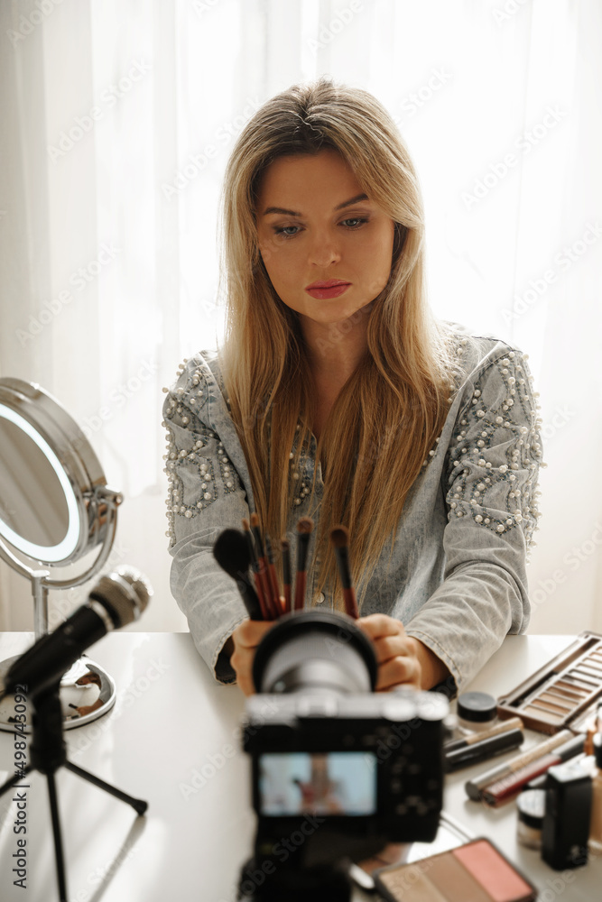 Beauty blogger making a video review of different make-up brushes for her followers Beauty blogger making a video review of different make-up brushes for her followers