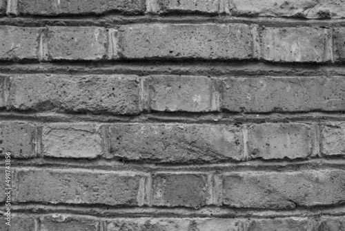 evocative black and white image of old orange bricks of an external perimeter wall 