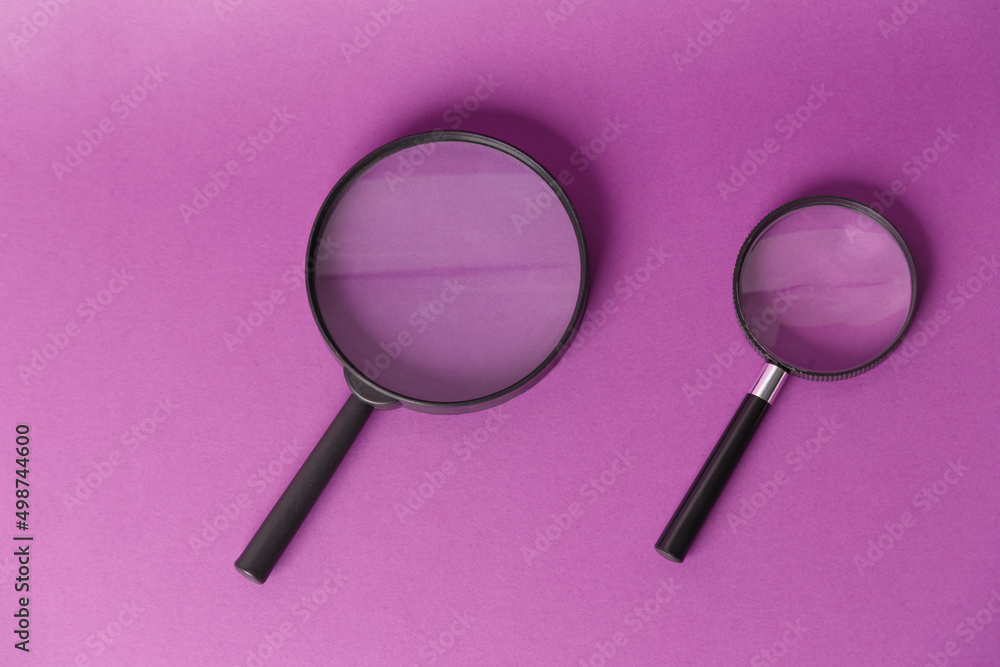 Two magnifying glasses, highlighted on a lilac background. View from above. A place to copy. Two magnifying glasses, highlighted on a lilac background. View from above. A place to copy.