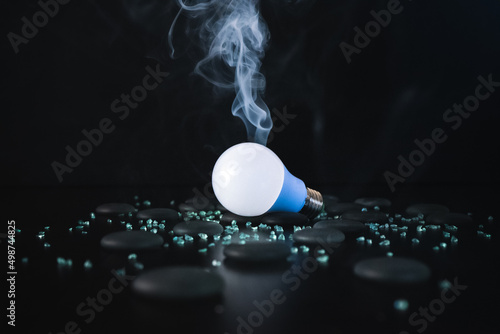 Lamp bulb on black background and little rocks