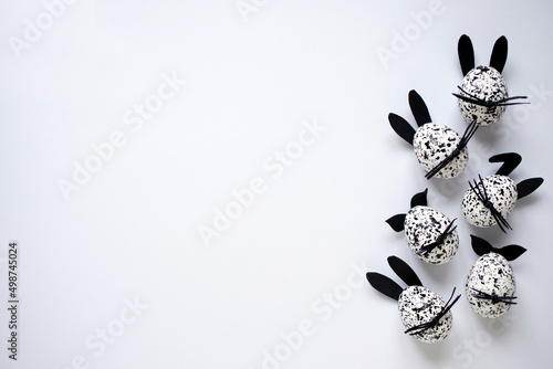 Easter background with Easter eggs, decorated as funny black and white bunnies on white background. photo