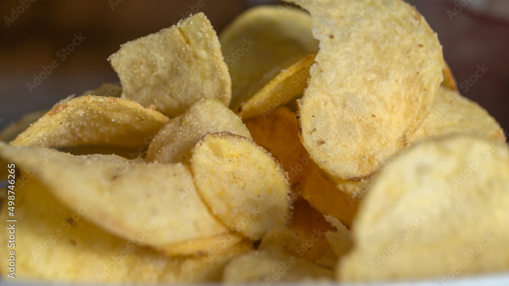 Chips on the plate under sunlight. Potato chips close up