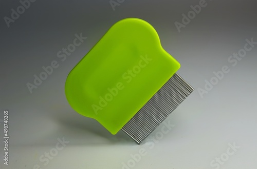 green lice comb floating, isolated on a grey background photo