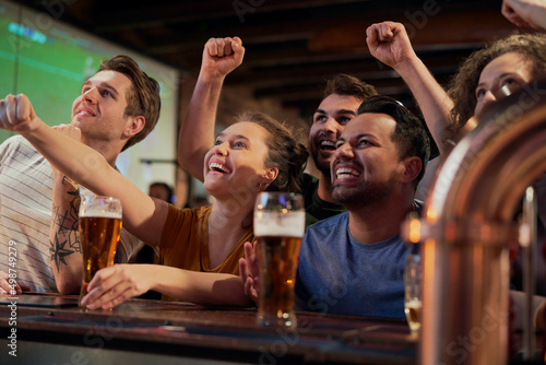 Fototapeta Naklejka Na Ścianę i Meble -  Cheering friends of soccer fans in the pub