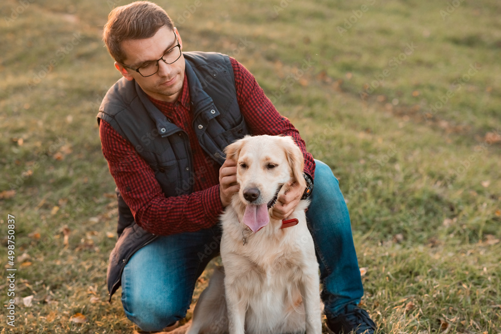 Golden retriever dog with owner on a walk outdoors Golden retriever dog with owner on a walk outdoors