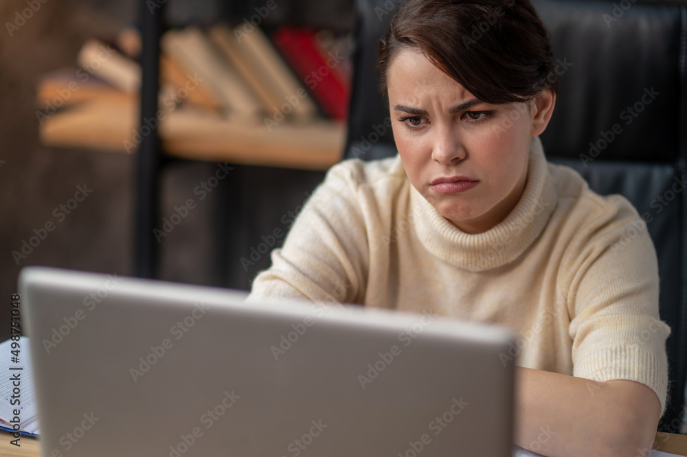 A woman in beige sweater looking tired and upset A woman in beige sweater looking tired and upset