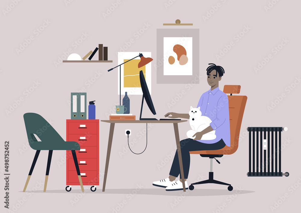 Fototapeta premium A young male African character working with a cat on their lap, home office interior