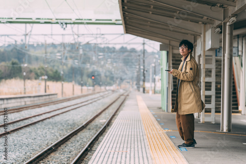 電車のホームで待つ人達