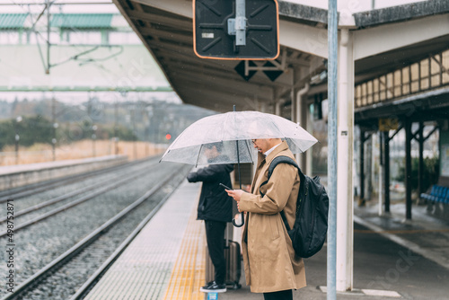 電車のホームで待つ人達