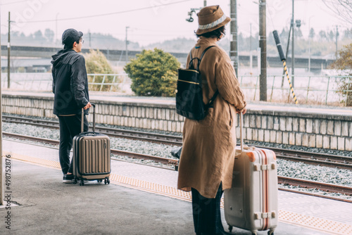 電車のホームで待つ人達