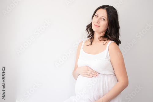 expecting mother with huge tummy. sweet pregnancy time. happy woman with pregnant belly in light bedroom. home cozy interior.