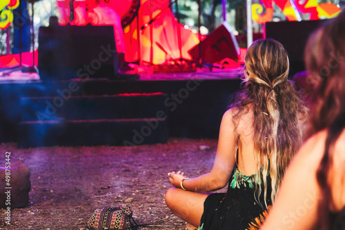 Fotografie Long haired blonde girl at a new-age festival at an ethnic music concert sitting