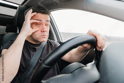 a sleepy man with closing eyes drives a car on the highway © andrey