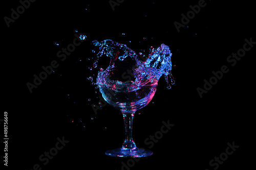 Glass with a splash of liqueur isolated on black background