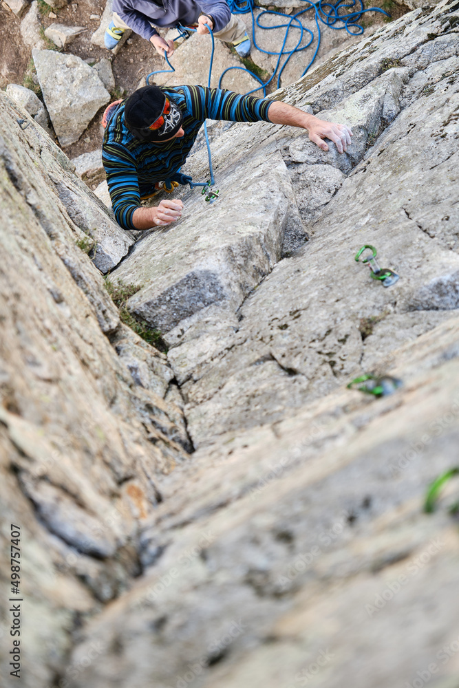 Man in harness climbing rock in highlands