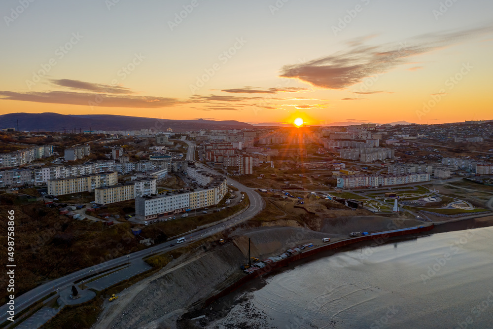 Obraz premium Aerial view of sunrise over the coastal city. Morning top view of the streets and buildings. City of Magadan, Magadan region, Siberia, Far East of Russia.