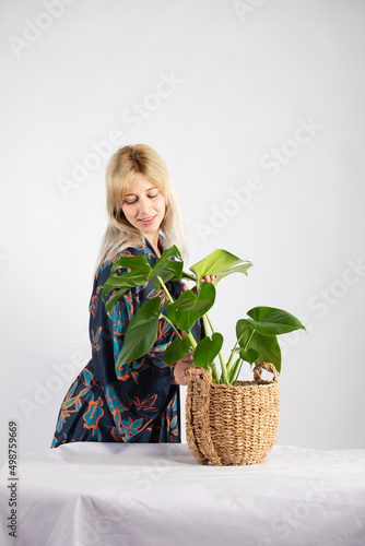 Attractive blonde woman in a black trendy and fashionable colorful kimono in a white background