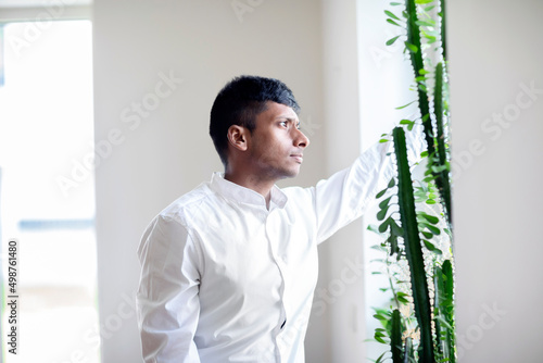 Junger Mann schaut aus dem Fenster