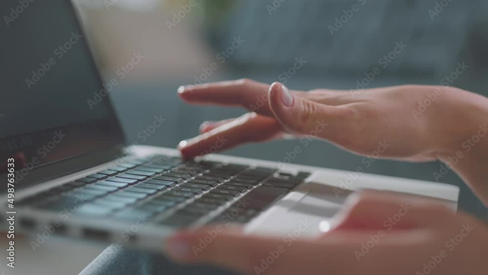 Female hands typing on laptop while sitting at office desk. Woman fingers tapping and texting in slow-motion while working in cabinet Female hands typing on laptop while sitting at office desk. Woman fingers tapping and texting in slow-motion while working in cabinet