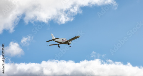 Single Engine Small Airplane taking off from an Airport. Cloudy Sky in Background.