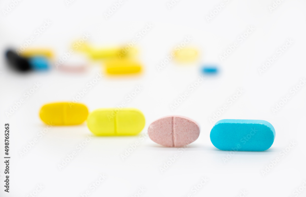 Different color pills isolate on white background, selective focus Different color pills isolate on white background, selective focus
