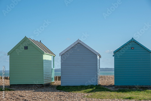 coloured beach huts on the beach at Calshot Hampshire England with the sea in the background