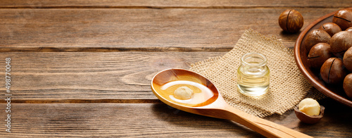 Fotografia, Obraz Macadamia oil and Macadamia nuts on a wooden background