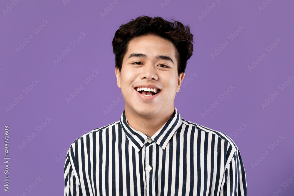 Portrait of smiling Asian man posing laughing at studio Portrait of smiling Asian man posing laughing at studio