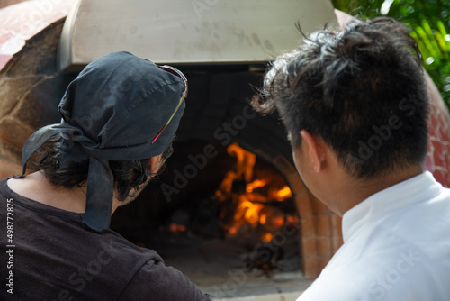 chef looking for the temperature in a wood-fired oven © Juanmarcos