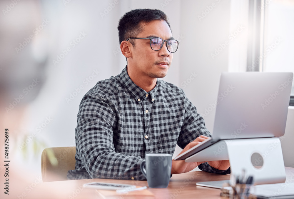 Its time to work. Shot of a young businessman using a laptop in an office. Its time to work. Shot of a young businessman using a laptop in an office.