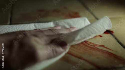 White Male Cleaning up blood from tiled floor photo