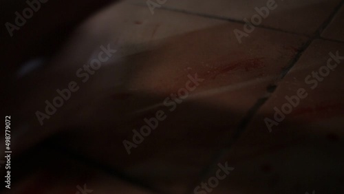 White Male Cleaning up blood from tiled floor