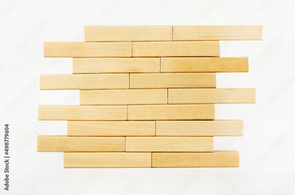 Close-up wall built with toy wooden blocks jenga. wooden brick tower on a white background.