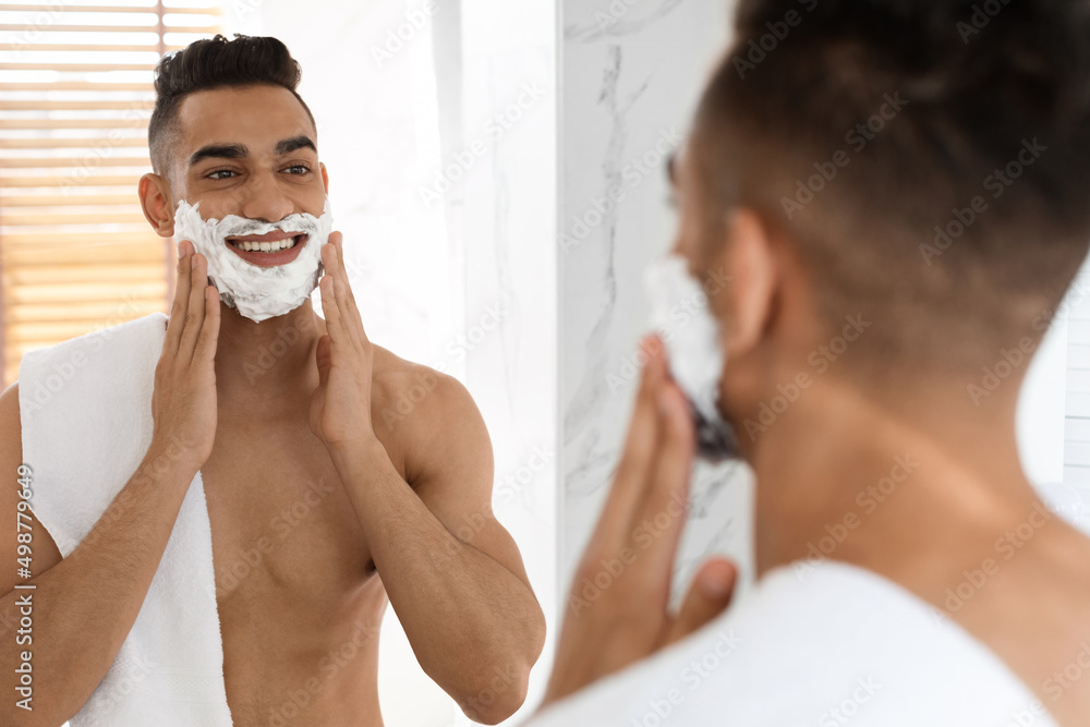 Morning Shaving. Handsome Shirtless Arab Guy Applying Shave Foam On Face
