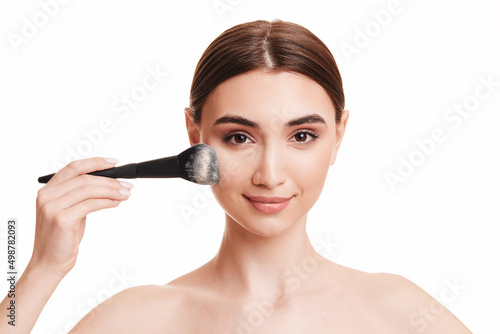 woman applying powder with make up brush