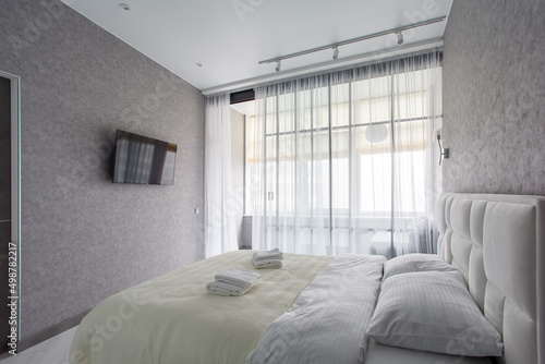 Master bedroom with sliding wardrobe and balcony door. Elegant and comfortable hotel bedroom interior