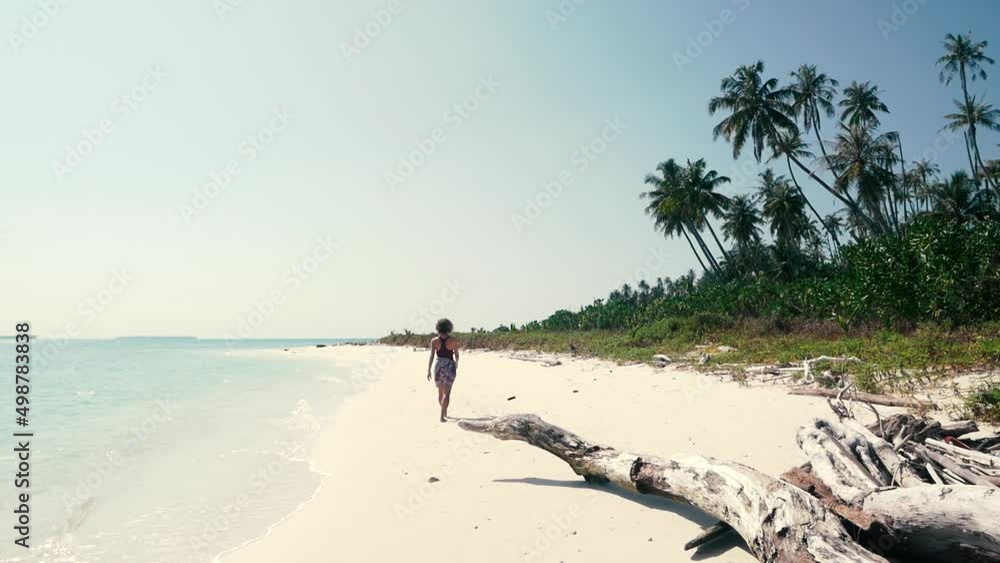 Slow motion: adult woman walking on tropical beach turquoise water caribbean sea white sand green coconut palm trees Banyak Islands Indonesia travel destination sunny day Slow motion: adult woman walking on tropical beach turquoise water caribbean sea white sand green coconut palm trees Banyak Islands Indonesia travel destination sunny day