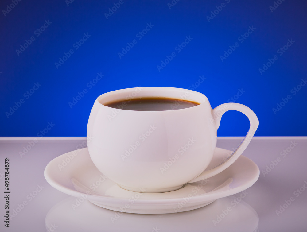 Cup of coffee in a white cup with saucer on a blue background. Cup of coffee in a white cup with saucer on a blue background.